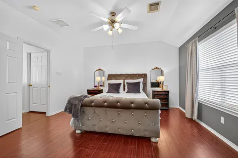 a bedroom with a bed and wooden floor