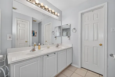 a bathroom with a sink double vanity mirror and bathtub