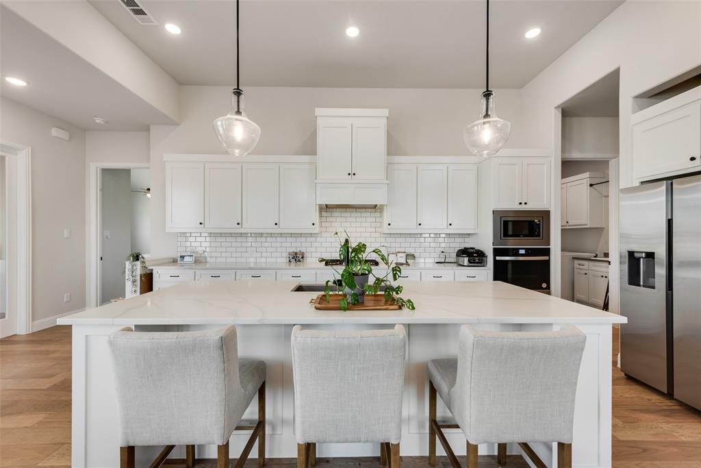 8922 Edna Place Rowlett, TX 75089 - Photo 13 of 37 Kitchen featuring tasteful backsplash, visible vents, light wood finished floors, and stainless steel appliances