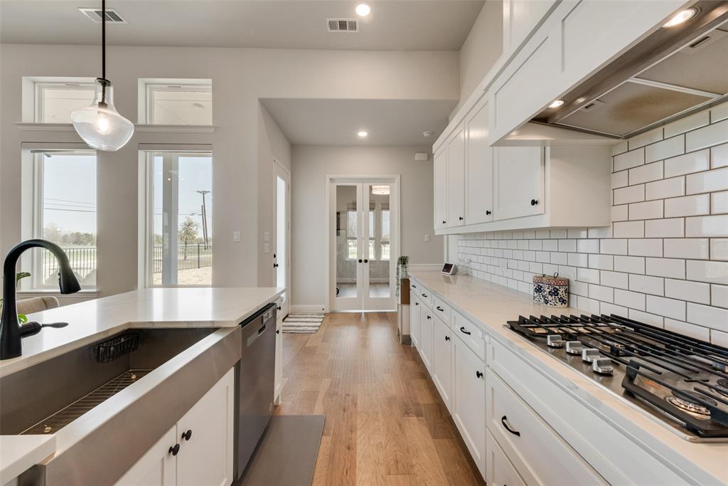 8922 Edna Place Rowlett, TX 75089 - Photo 14 of 37 Kitchen featuring visible vents, french doors, appliances with stainless steel finishes, wall chimney exhaust hood, and light wood finished floors
