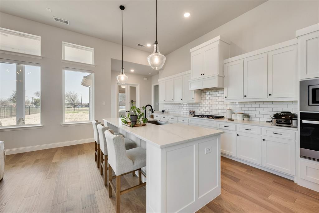 8922 Edna Place Rowlett, TX 75089 - Photo 15 of 37 Kitchen featuring visible vents, a sink, tasteful backsplash, white cabinetry, and appliances with stainless steel finishes