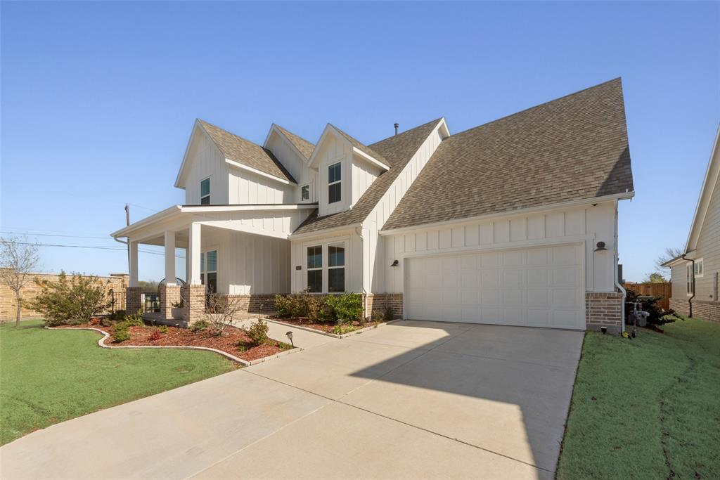 8922 Edna Place Rowlett, TX 75089 - Photo 2 of 37 View of front facade with a garage, board and batten siding, concrete driveway, and a front yard