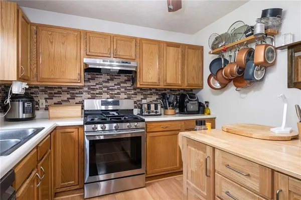 a kitchen with a stove a sink and cabinets