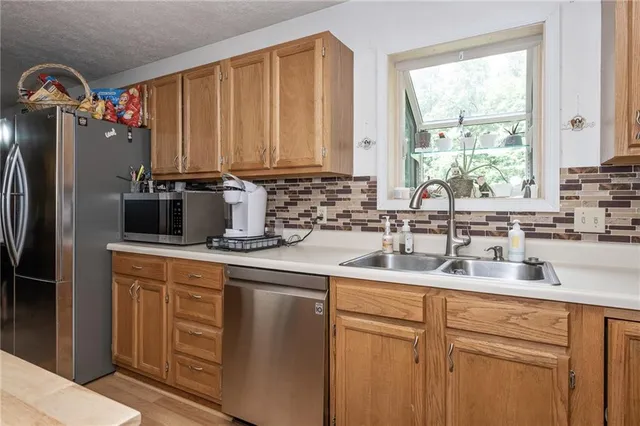 a kitchen with stainless steel appliances granite countertop a sink a refrigerator and a granite counter tops