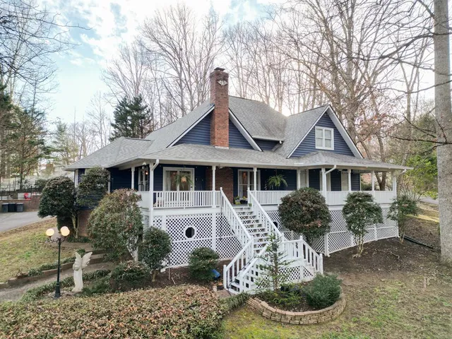 a front view of a house with a yard and potted plants