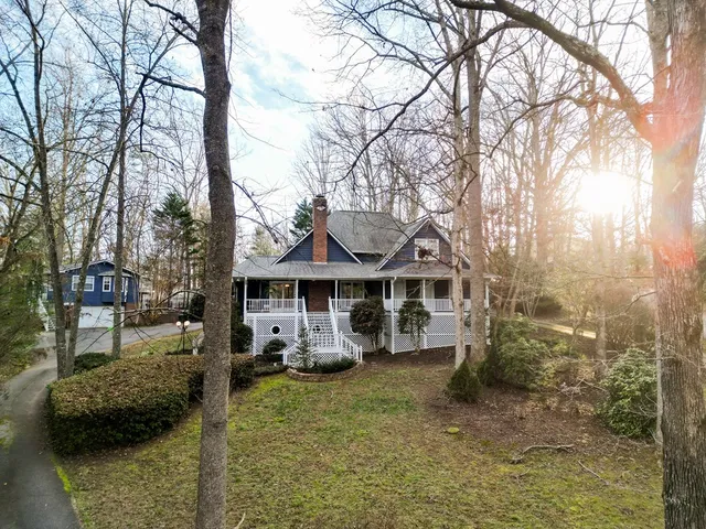 a front view of a house with a tree