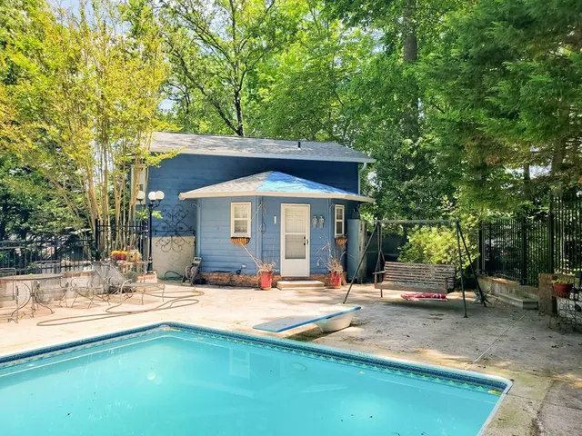 a view of a house with swimming pool and sitting area