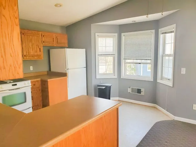 a room with wooden cabinets and window