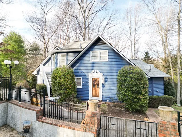 a front view of a house with a yard and potted plants
