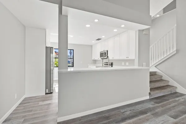 a view of kitchen with wooden floor and electronic appliances