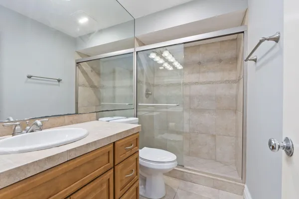 a bathroom with a sink a toilet and shower