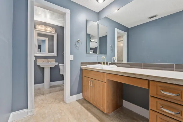 a spacious bathroom with a sink and a mirror