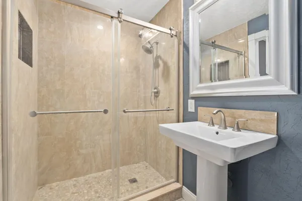 a bathroom with a shower sink and mirror