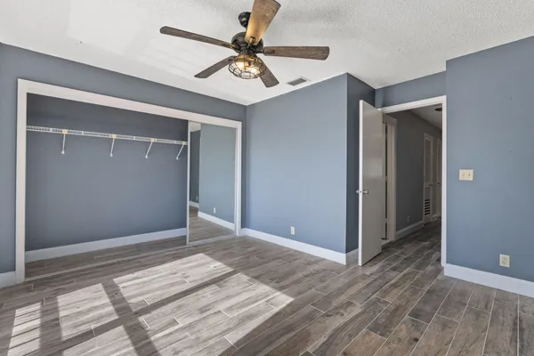 a view of a livingroom with wooden floor and a ceiling fan
