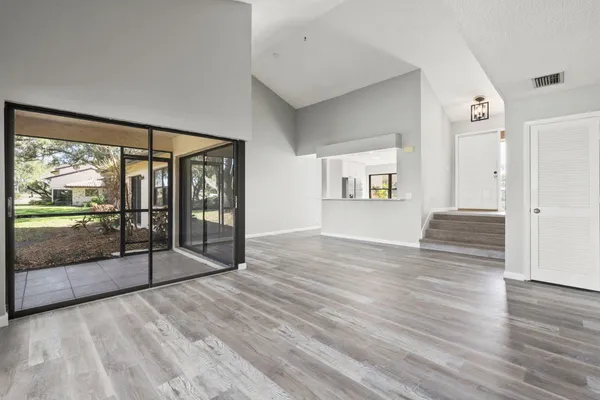 a view of a big room with wooden floor and windows