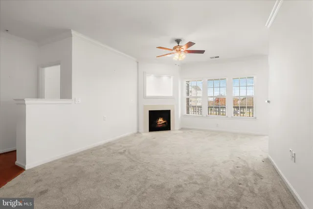 a view of an empty room with a fireplace and a window