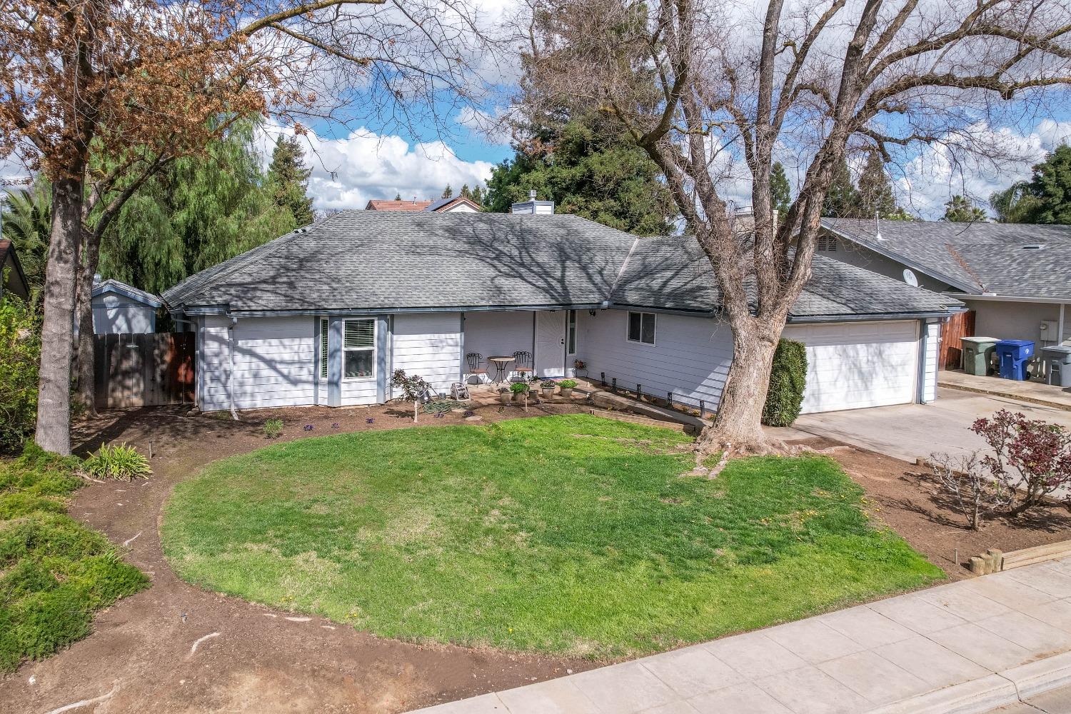695 West Polson Avenue Clovis, CA 93612 - Photo 4 of 27 a front view of a house with a garden and trees