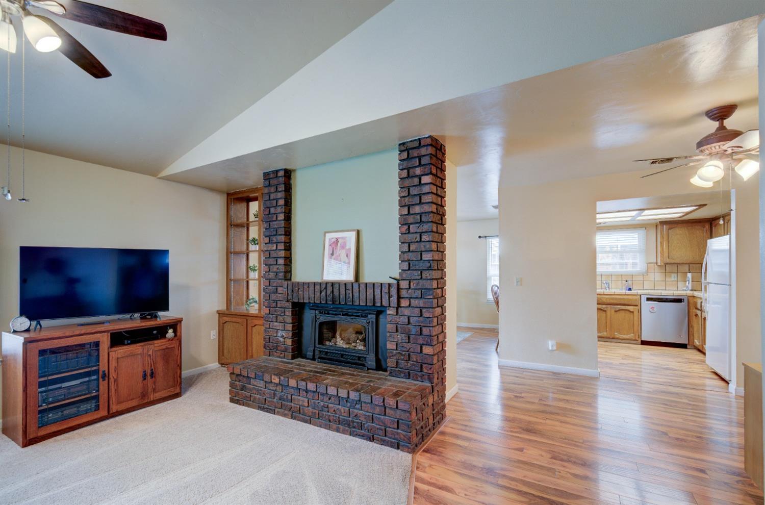 695 West Polson Avenue Clovis, CA 93612 - Photo 5 of 27 a living room with furniture a flat screen tv and a fireplace