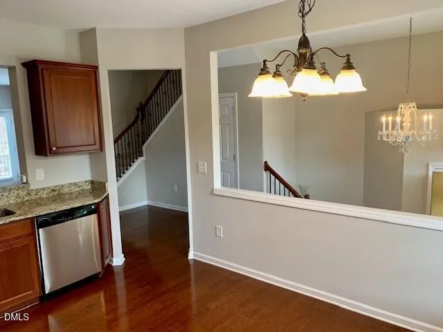 a view of a kitchen with a sink dishwasher a refrigerator and wooden floor