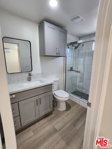 a bathroom with a granite countertop sink toilet and shower