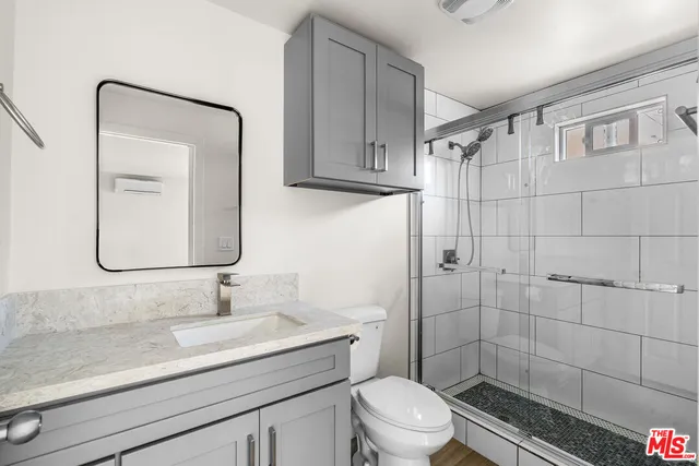 a bathroom with a sink a toilet and shower