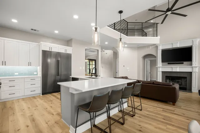 a kitchen with sink microwave cabinets dining table and chairs