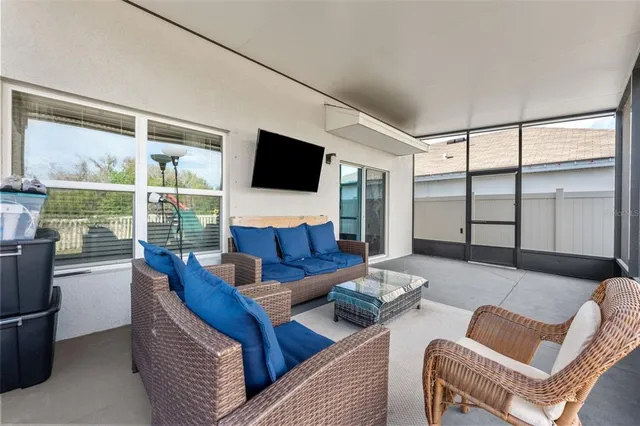 a living room with furniture a flat screen tv and a floor to ceiling window