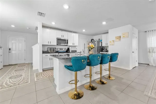 a kitchen with stainless steel appliances kitchen island granite countertop a refrigerator and cabinets