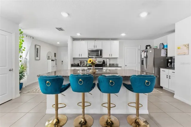 a kitchen with stainless steel appliances granite countertop a refrigerator and a stove top oven