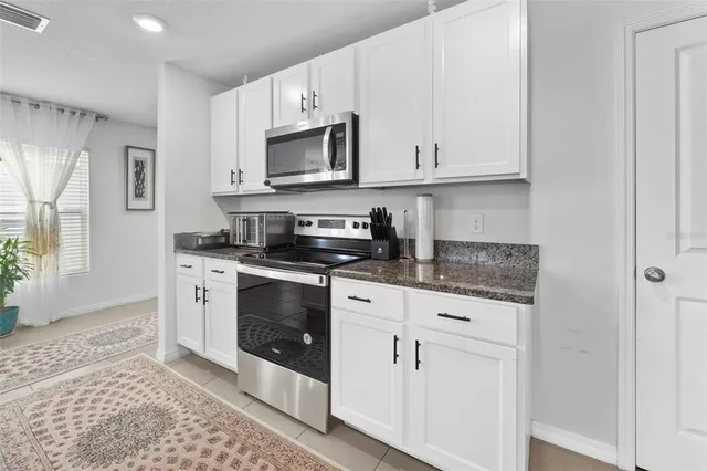 a kitchen with white cabinets stainless steel appliances and sink