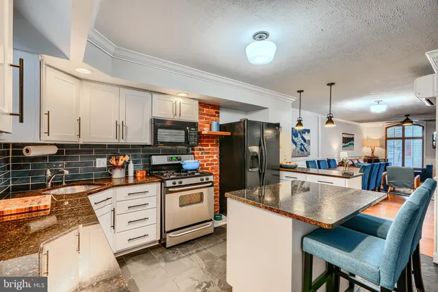 a kitchen with stainless steel appliances granite countertop a stove a sink and a refrigerator