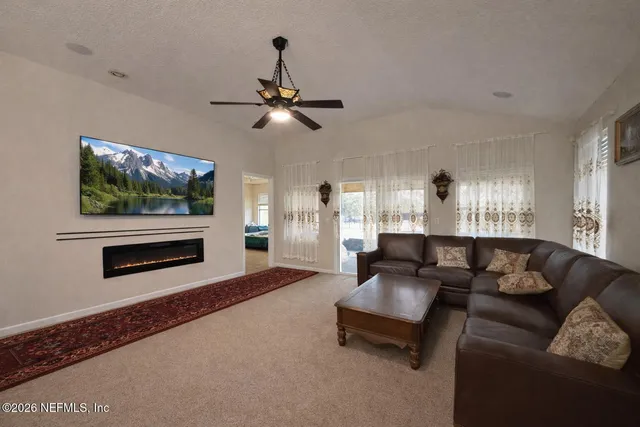 a living room with furniture a flat screen tv and a window
