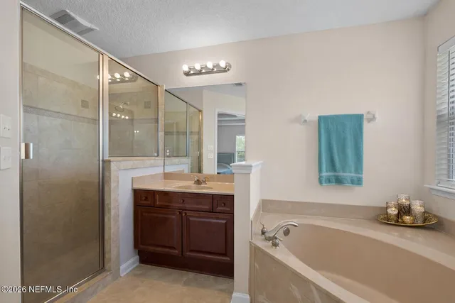 a bathroom with a tub sink and mirror