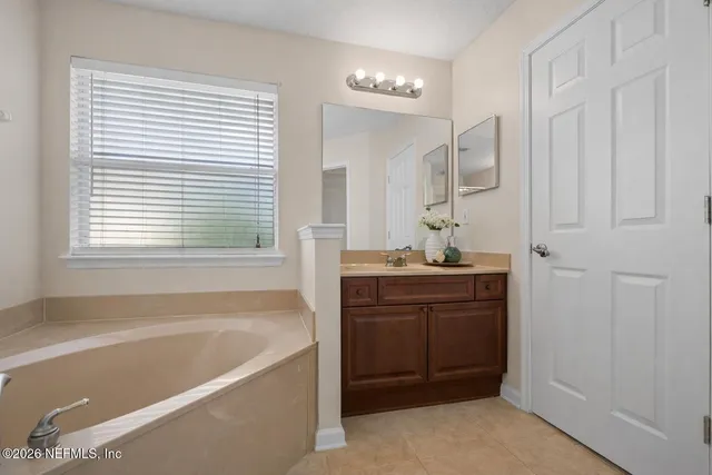 a bathroom with a tub sink and mirror