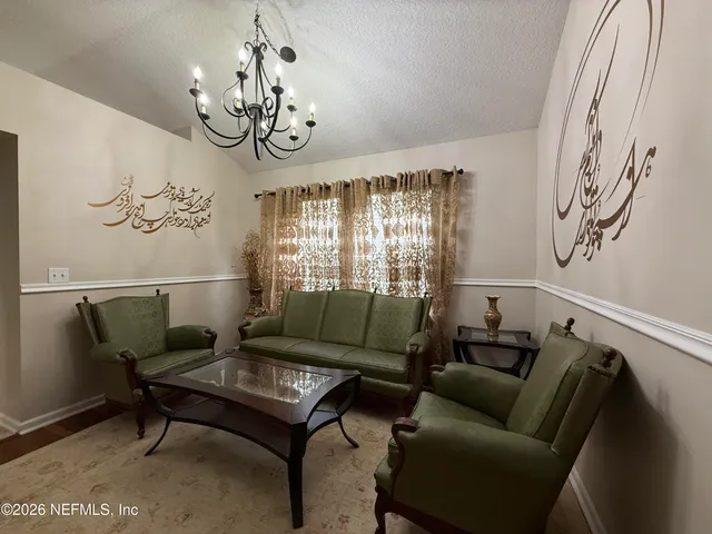 a living room with furniture and a chandelier
