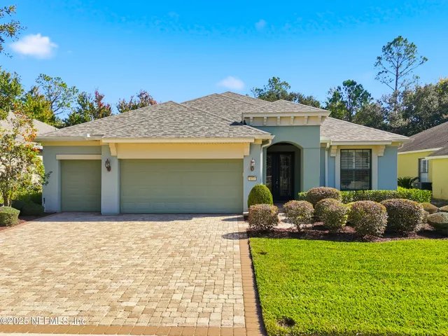 a front view of a house with a garden and plants