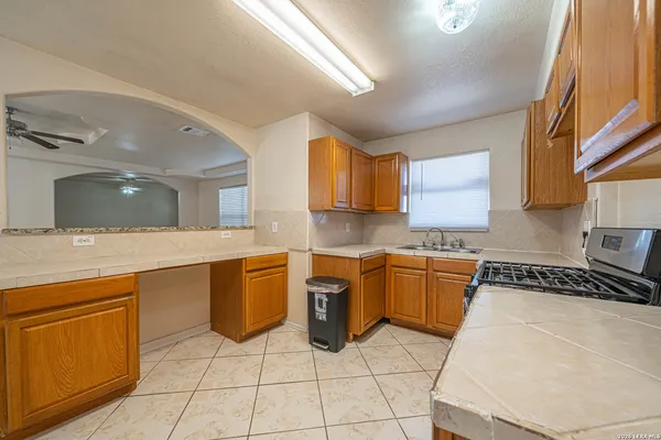 a kitchen with stainless steel appliances granite countertop a sink stove and cabinets