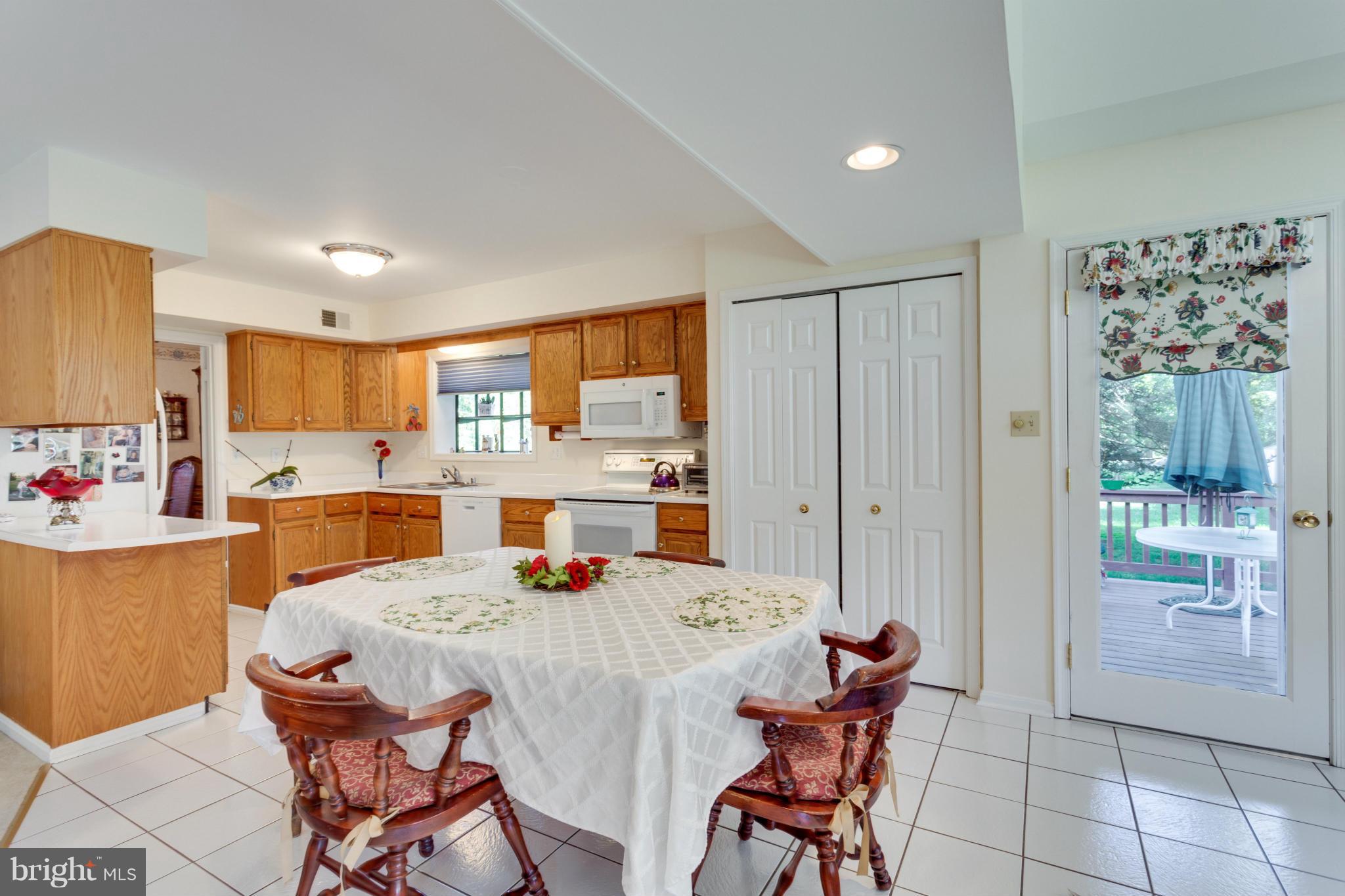 11611 Vale Road Oakton, VA 22124 - Photo 8 of 30 a kitchen with a table chairs refrigerator and cabinets