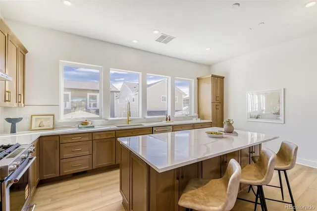 a kitchen with a sink a stove and chairs