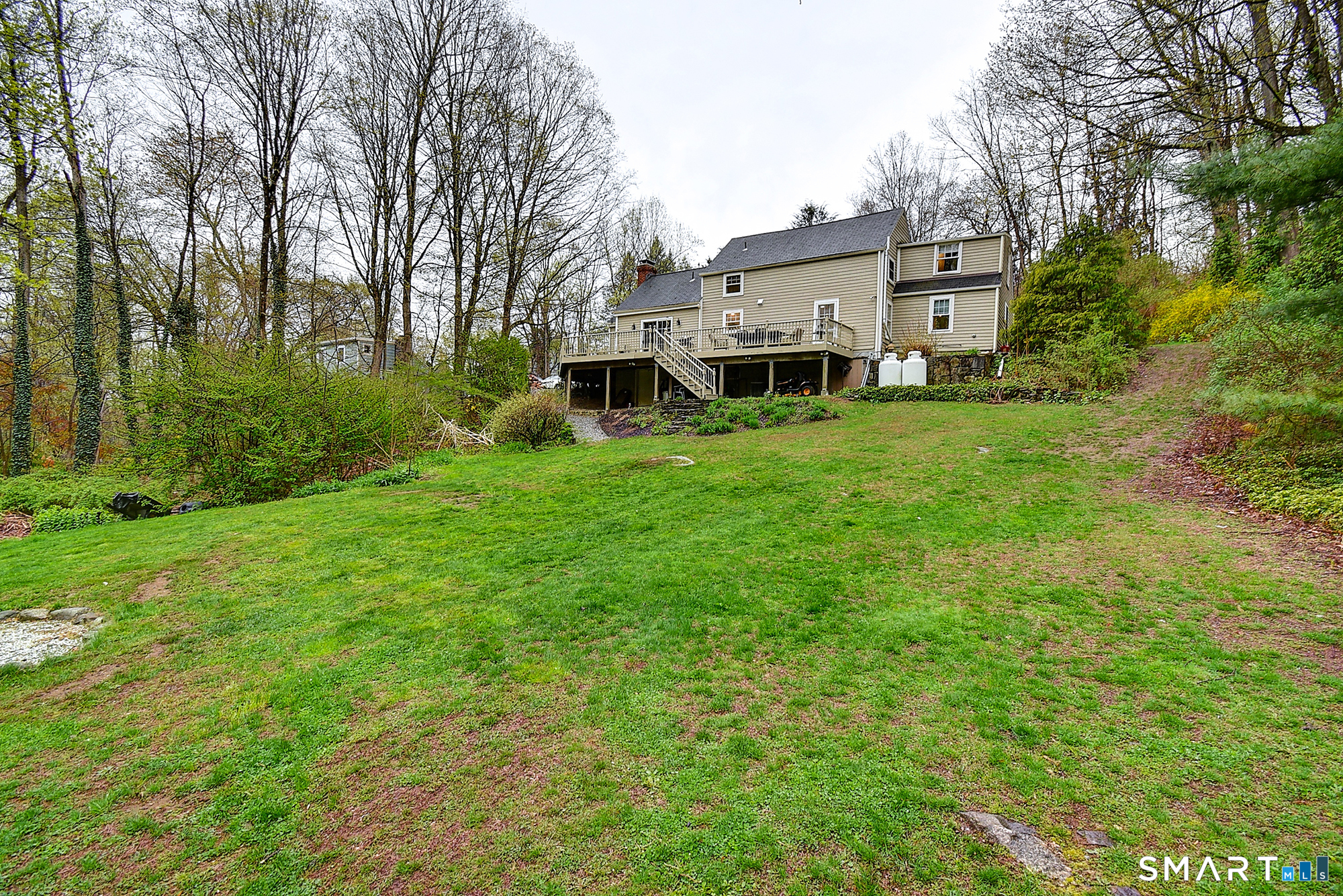 27 Chestnut Hill Road Newtown, CT 06482 - Photo 5 of 36 a front view of a house with a garden and trees