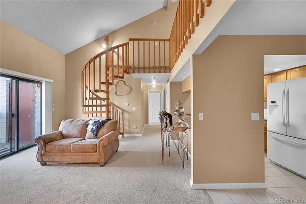 a living room with furniture stairs and a chandelier