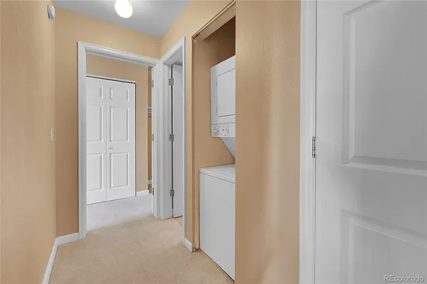 a view of a hallway with a white cabinet and a door