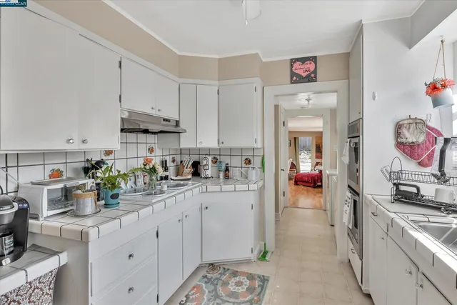 a kitchen filled with white cabinets and appliances