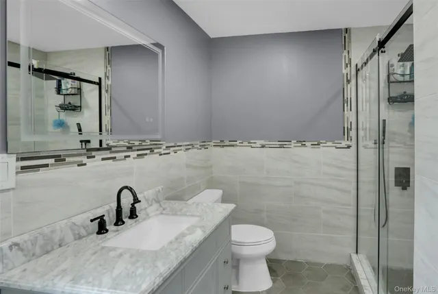 a bathroom with a granite countertop sink toilet and shower