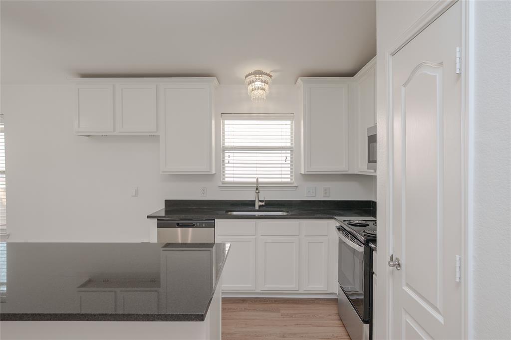 2912 Lighthouse Drive Denton, TX 76210 - Photo 11 of 34 a kitchen with granite countertop a sink stove and cabinets