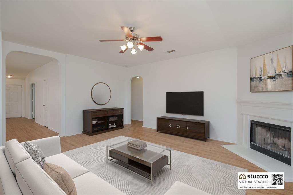 2912 Lighthouse Drive Denton, TX 76210 - Photo 19 of 34 a living room with furniture a fireplace and a flat screen tv