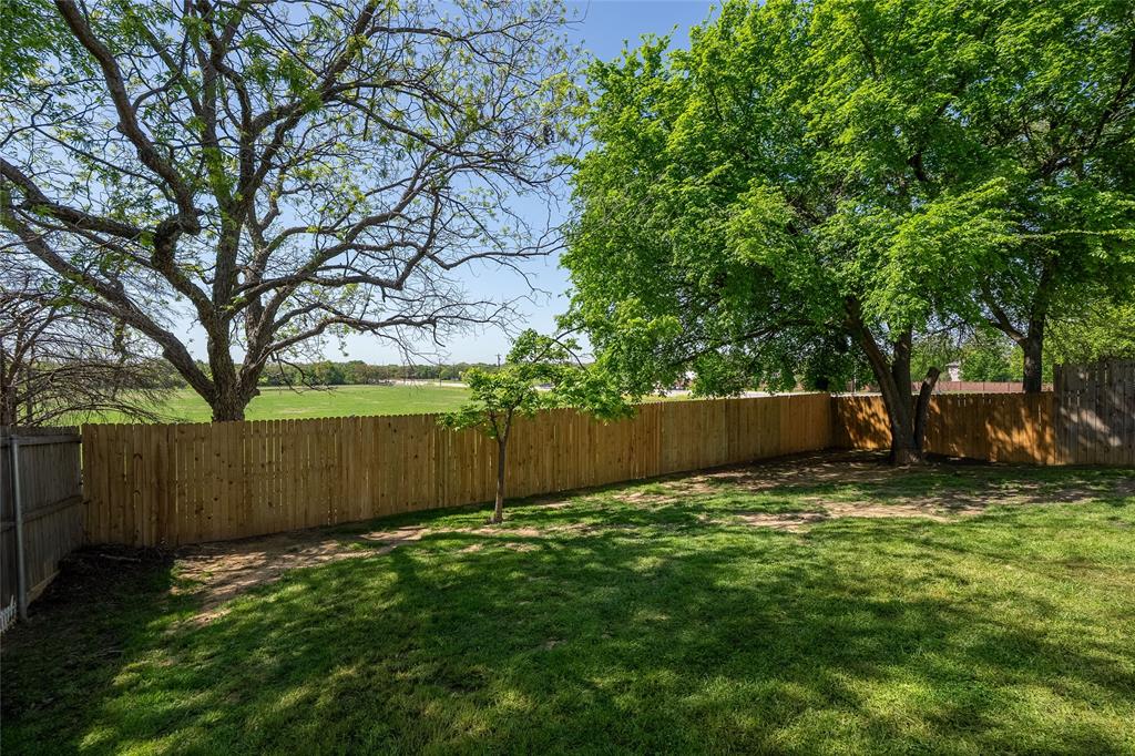 2912 Lighthouse Drive Denton, TX 76210 - Photo 34 of 34 a view of a backyard with a tree and wooden fence