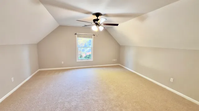 an empty room with a window and a ceiling fan