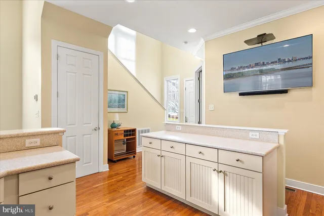 a kitchen with cabinets stainless steel appliances and wooden floor