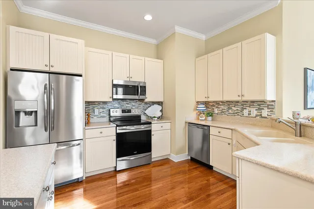 a kitchen with stainless steel appliances granite countertop a refrigerator sink and stove